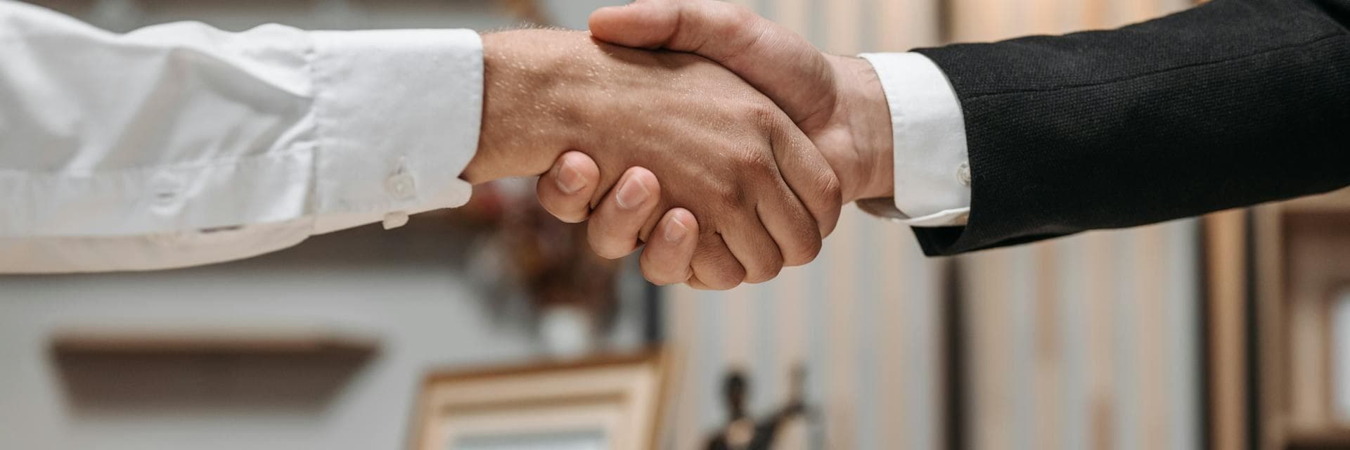 Handshake in een notariskantoor — partnerschap met Asbestify voor asbestattesten bij verkoop en overdracht