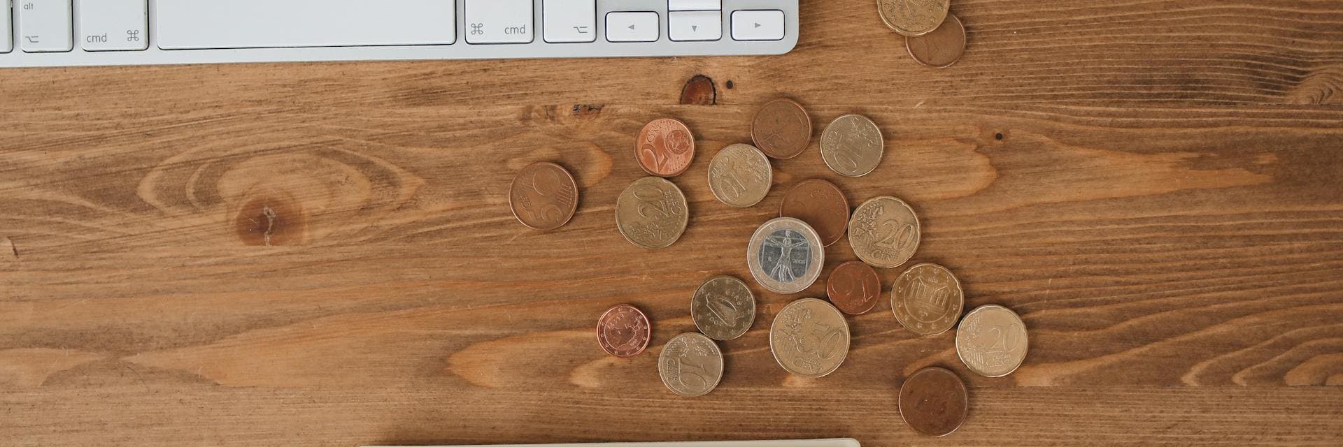 Euromunten op een houten bureau — transparante tarieven voor asbestattest